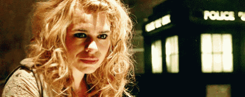 a woman is standing in front of a police box .