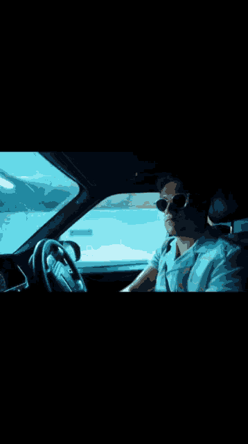 a man wearing sunglasses is sitting in a car