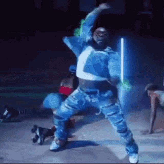 a man in a blue jacket is dancing on a stage