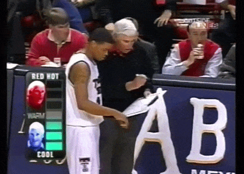 a basketball player is standing in front of a sign that says " red hot "