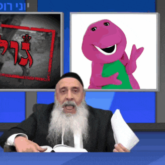 a man with a beard is sitting in front of a screen with a picture of barney on it