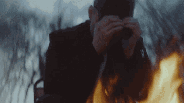 a man is taking a picture of a fire with a camera
