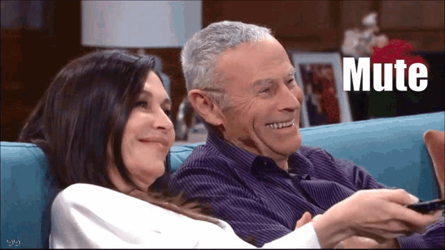 a man and a woman are sitting on a couch with the word mute in the corner