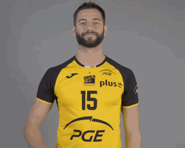 a man with a beard wears a yellow shirt with the number 15 on it