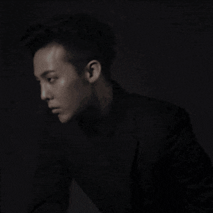 a black and white photo of a young man in a suit and turtleneck