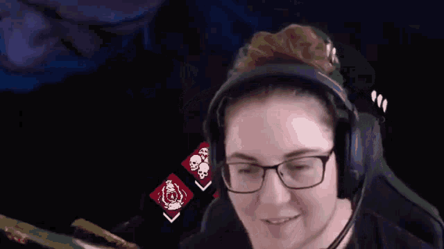 a woman wearing headphones and glasses is sitting in a video game chair .