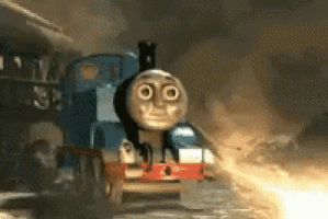a thomas the tank engine train is going through a smokey tunnel .