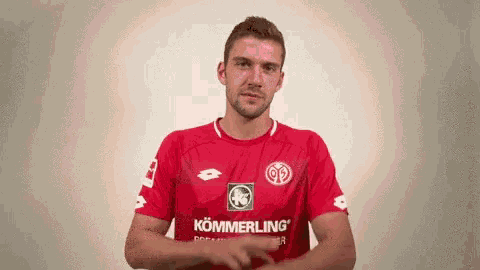 a man wearing a red shirt that says kömmerling on it