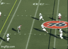 a football game is being played in front of a large birmingham bowl sign