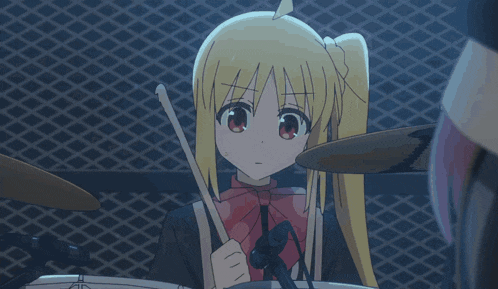 a girl with blonde hair is playing drums in front of a fence