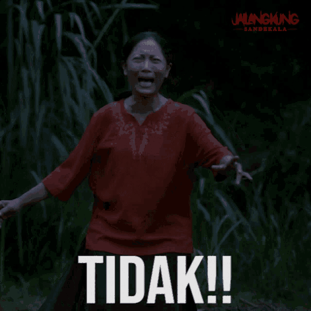 a woman in a red shirt is screaming with the words tidak in white letters