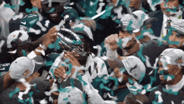 a group of eagles players are celebrating with confetti and a trophy