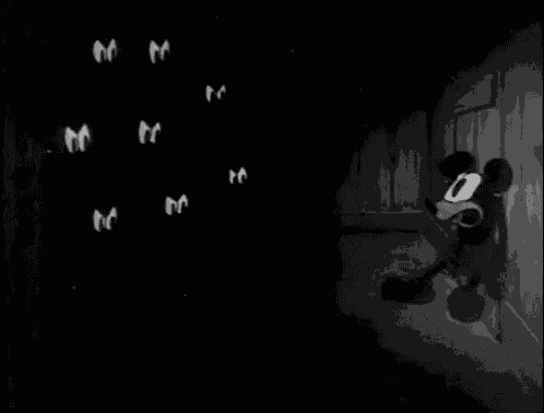 mickey mouse is standing in front of a bunch of chickens