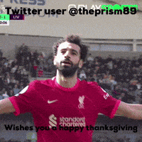 a man with a beard wearing a red shirt that says standard chartered on it