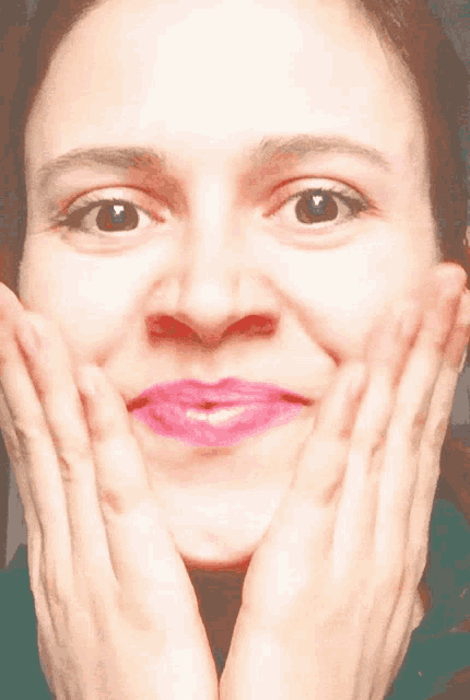 a close up of a woman 's face with pink lipstick