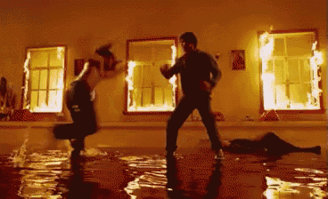 a man and woman are dancing in a room filled with fire