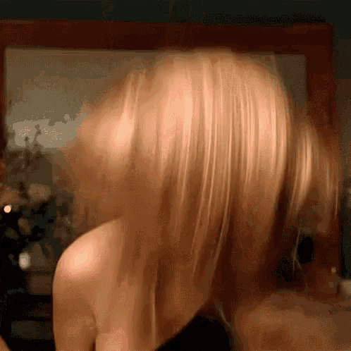 a close up of a woman 's hair being blown in the wind in front of a mirror .