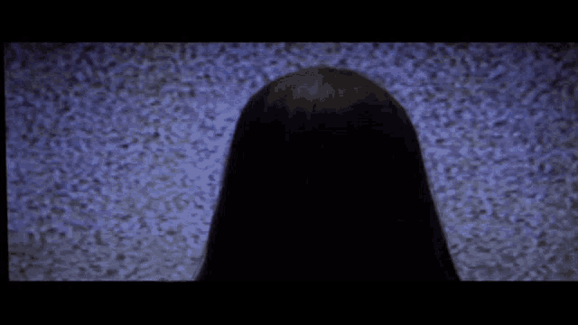 a woman 's head is visible in a dark room .
