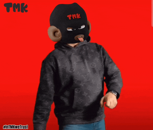 a man wearing a mask with the word tmk on it is giving the middle finger