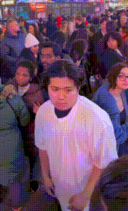 a man in a white shirt stands in the middle of a crowd of people