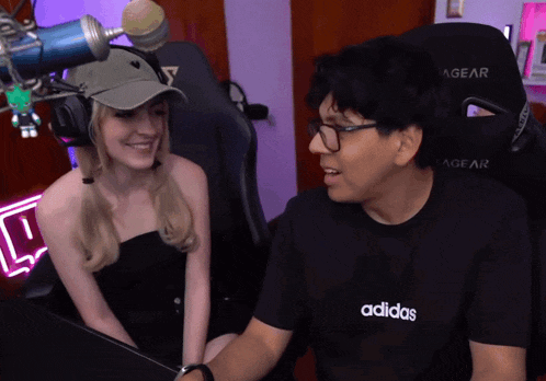 a man wearing an adidas t-shirt talks to a woman