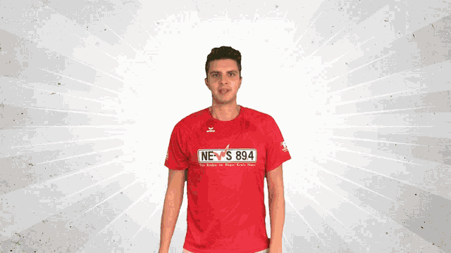 a man in a red news 894 shirt is dancing