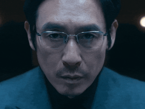 a close up of a man 's face with glasses and a beard
