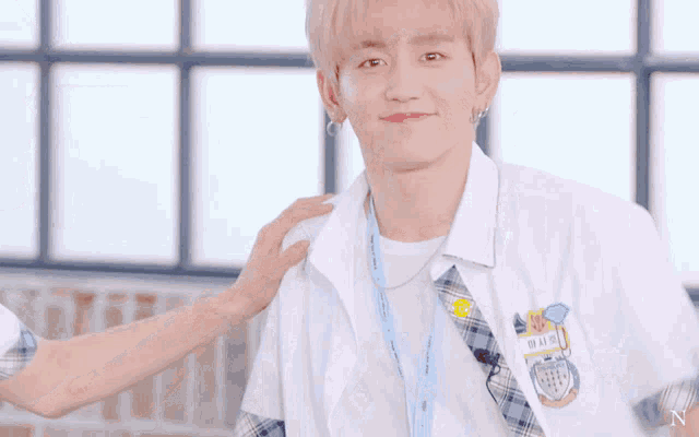 a person putting their hand on a boy 's shoulder with a name tag that says n on it