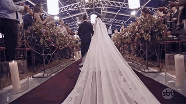 the bride and groom are walking down the aisle at their wedding .