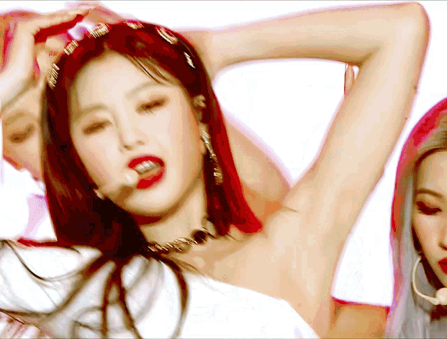 a woman with red hair is singing into a microphone while wearing a choker