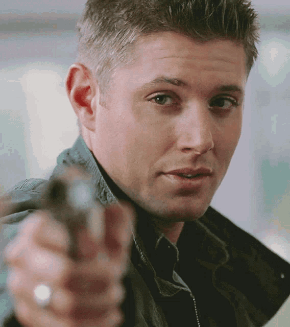 a man with a ring on his finger is holding a gun