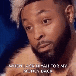 a man with a beard is wearing a fur coat and looking at the camera .