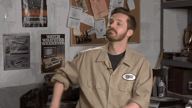 a man stands in front of a bulletin board with a poster that says watch whatever whenever