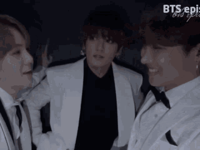 three men in tuxedos are standing next to each other in front of a screen that says bts epi