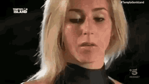 a close up of a woman 's face with the words temptation island in the background .