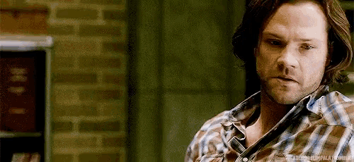 a man in a plaid shirt is looking at the camera .