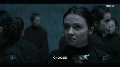 a woman in a dark room says choose in front of a group of people