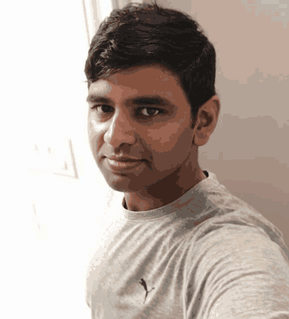 a man wearing a grey shirt with a puma logo on the front