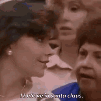 a group of women are talking and one of them says i believe in santa claus .