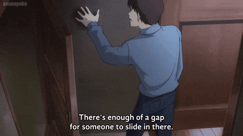 a man in a blue shirt is reaching for something in a dark room