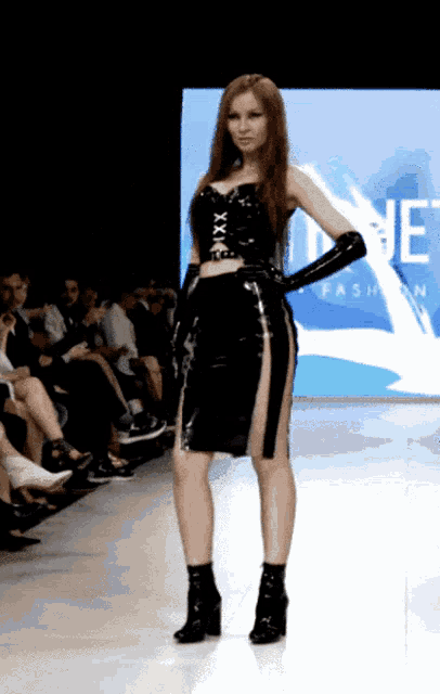 a model walks down the runway at a fashion show in front of a sign that says ne fashion