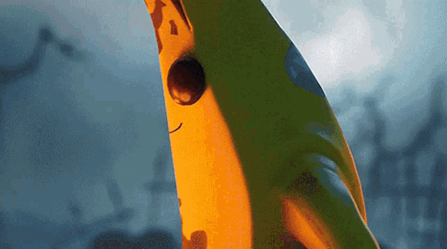 a close up of a yellow and green object with a face