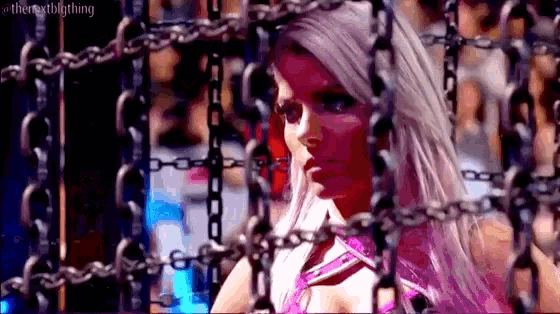 a woman in a pink dress is chained to a chain link fence
