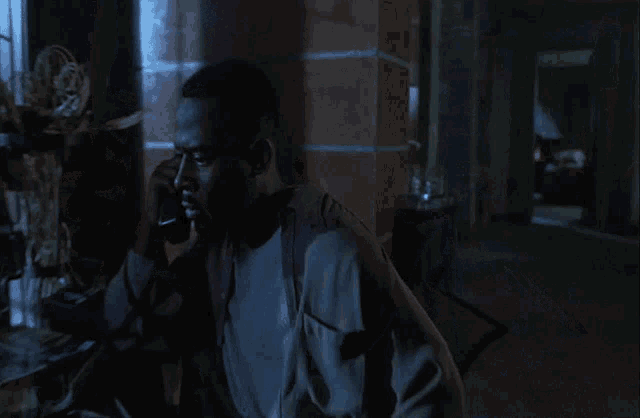 a man talking on a phone in the dark