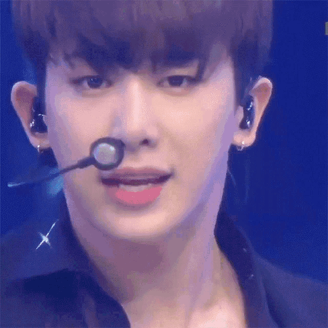 a close up of a person 's face with a microphone in his mouth
