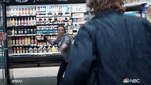 two people are fighting in a grocery store and the nbc logo is visible