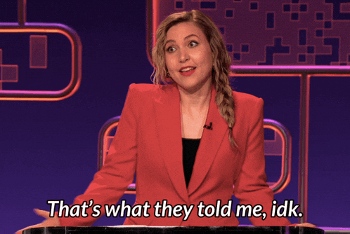a woman in a red jacket stands in front of a podium and says that 's what they told me idk