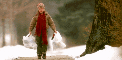 a person wearing a red scarf and a brown jacket is carrying two plastic bags