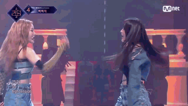 two women are fighting on a stage and the words high tension are on the screen