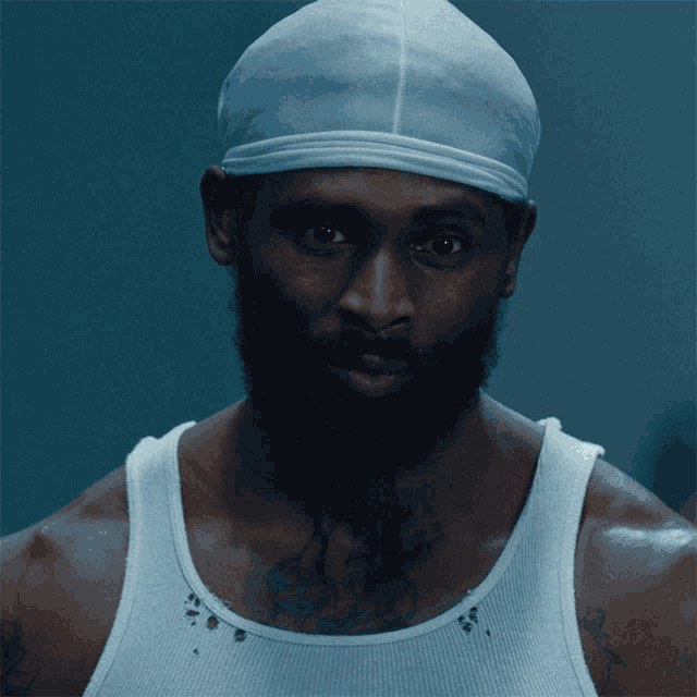 a man wearing a white tank top and a blue headband